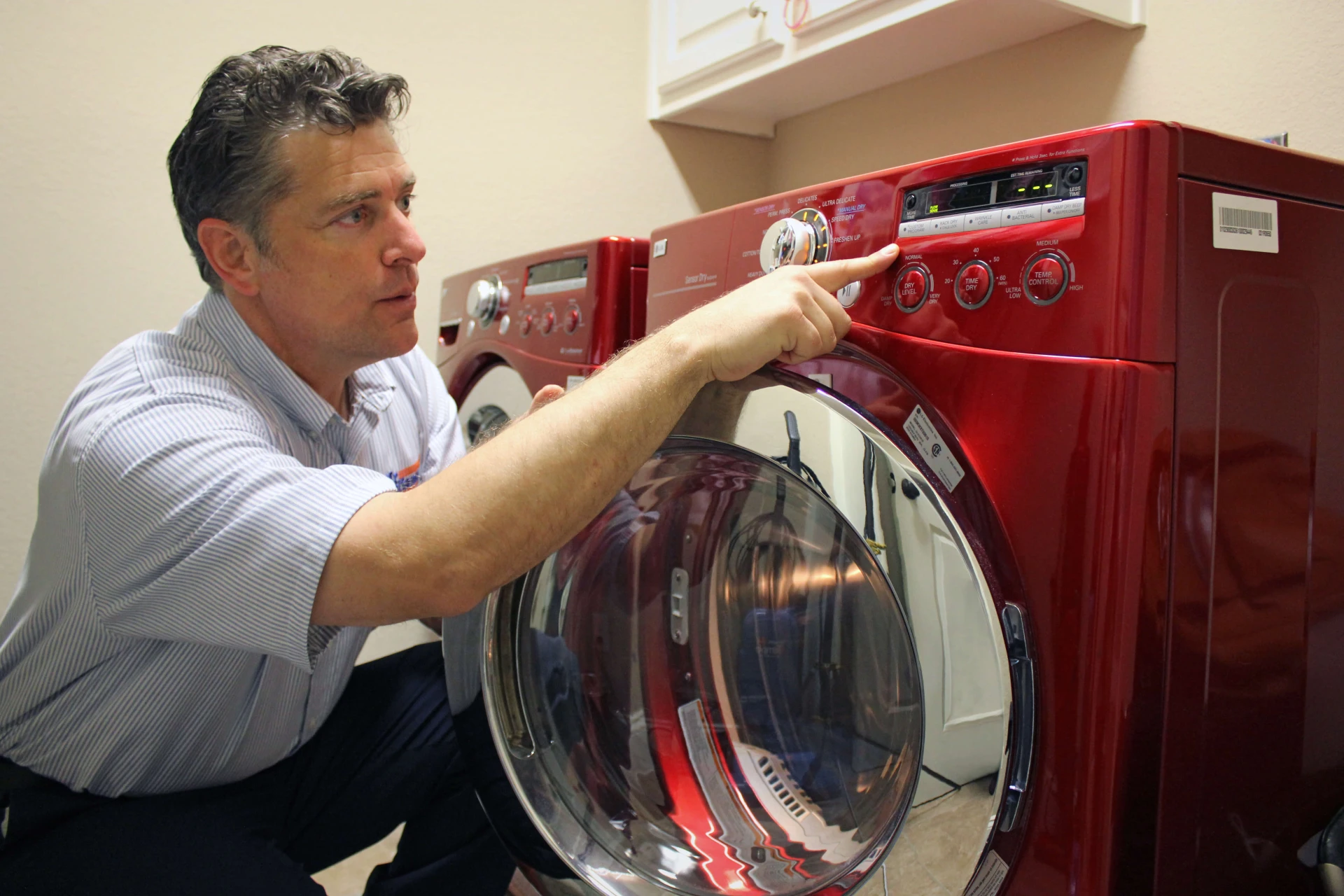 alt="Mr. Appliance technician servicing a washer and dryer"