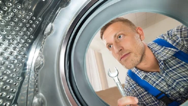 Appliance repair tech servicing a washer