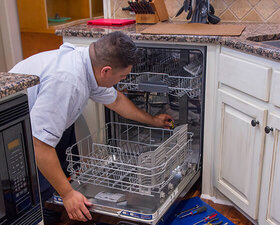 A Mr. Appliance handyman performing a dishwasher repair 