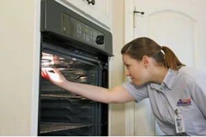 Mr Appliance technician repairing a residential oven.