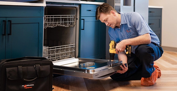 A Mr. Appliance technician repairing a dishwasher.