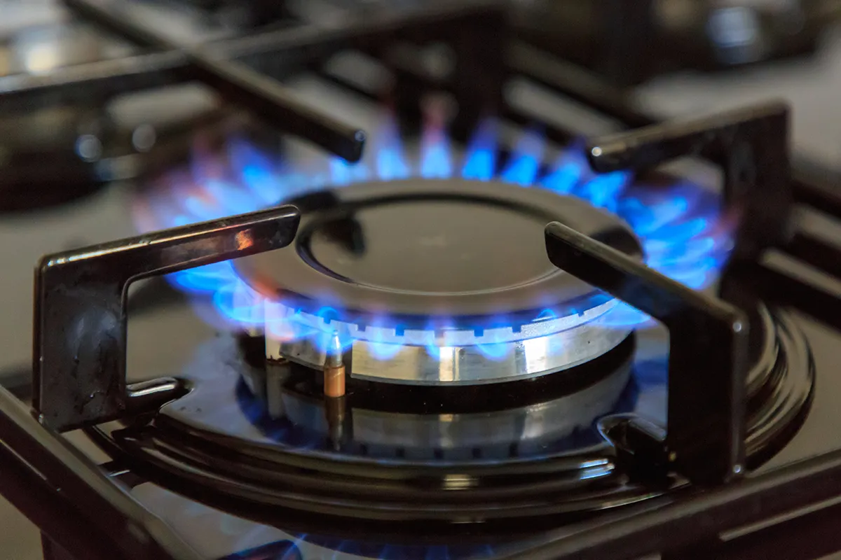 Ignited gas burner burning blue and orange.