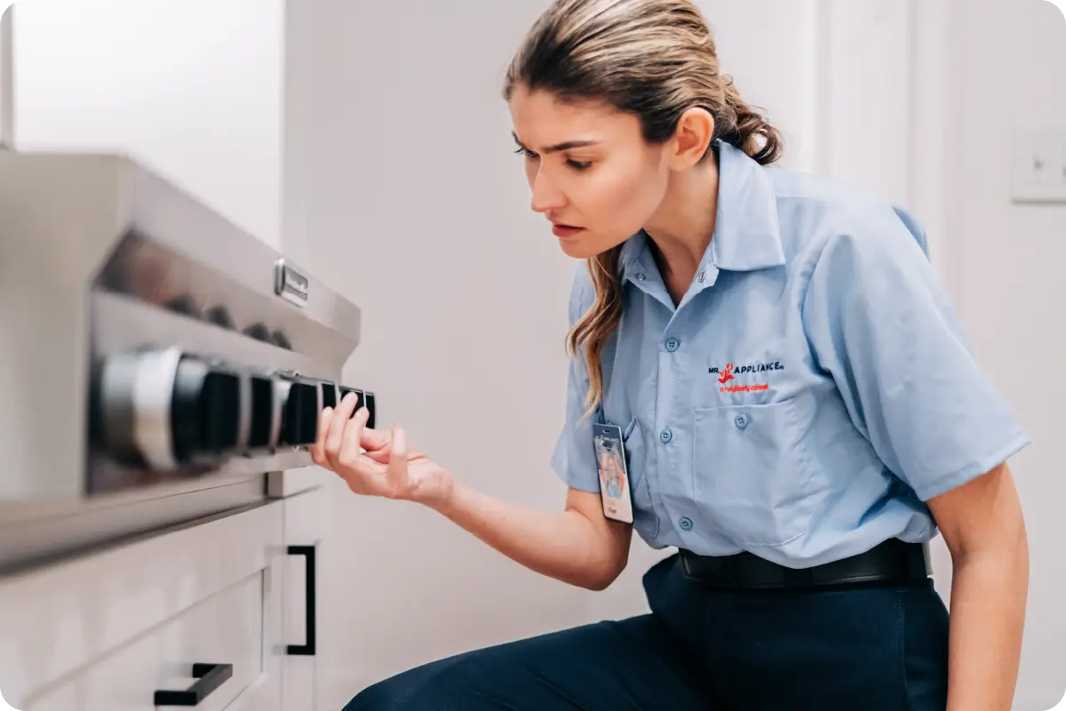 Image of a woman inspecting oven knobs.