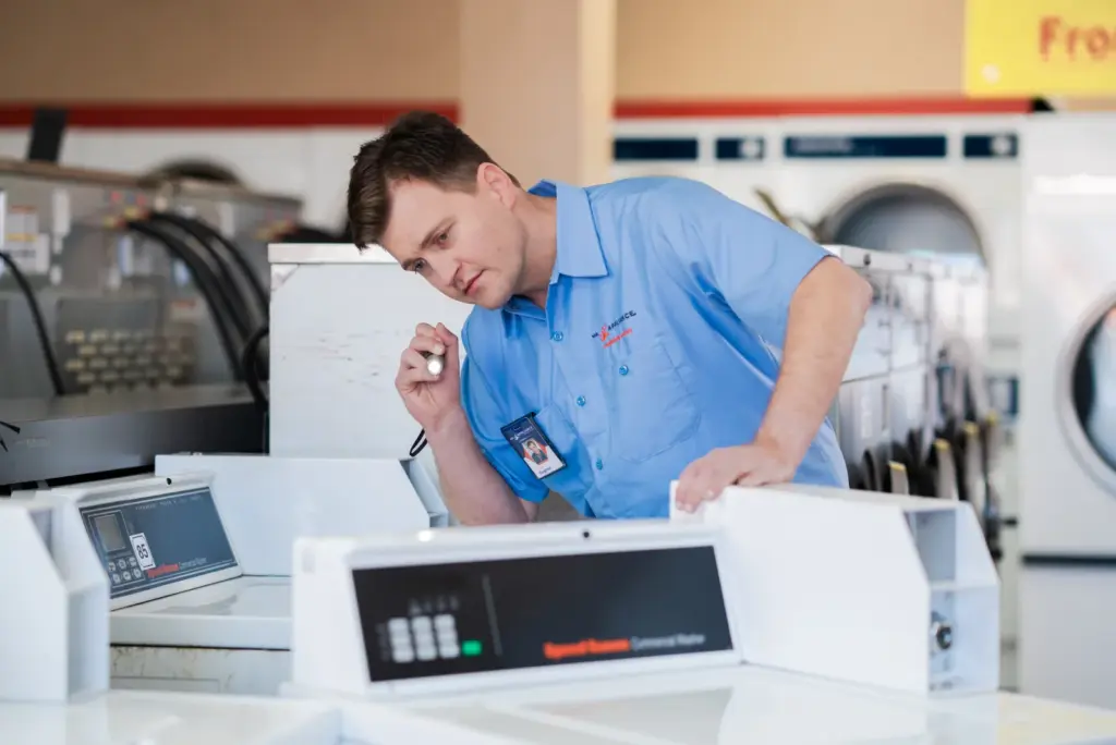 Mr. Appliance service professional inspecting an appliance.