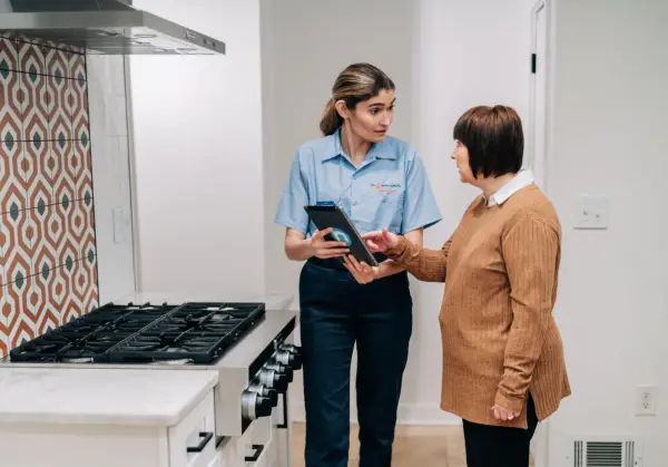 Mr. Appliance professional and woman talk about stoves.