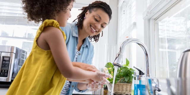 Mother and daughter washing their hands