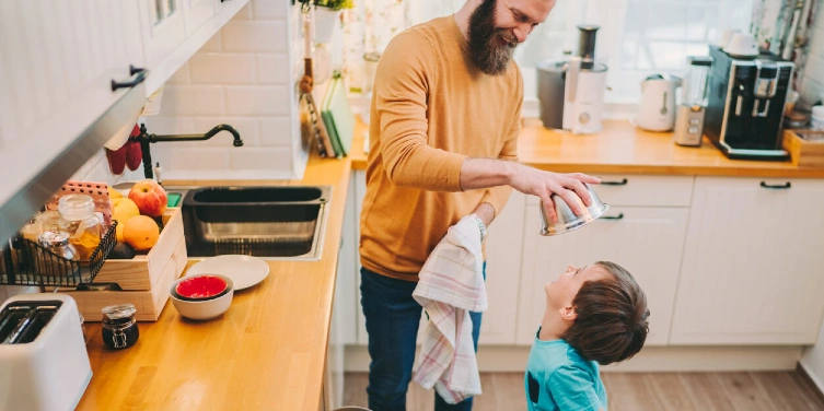 Dad and son emptying dishwasher