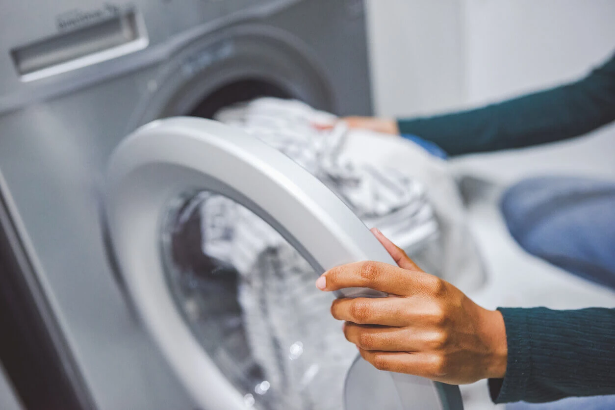 Woman taking clothes out of laundry machine