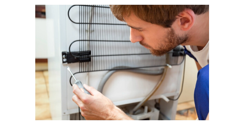 Appliance repair tech servicing an appliance