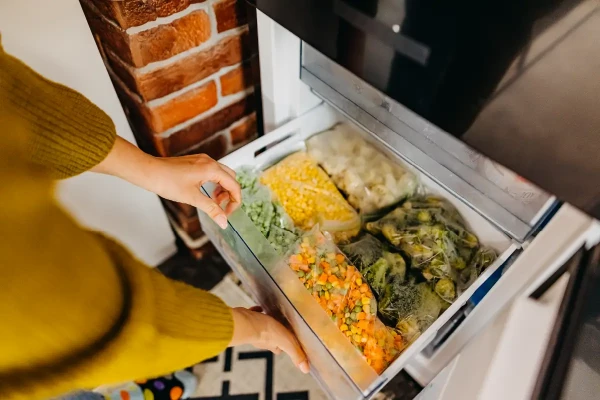 Woman opening stocked freezer