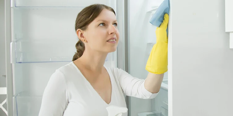 Woman cleaning a refrigerator