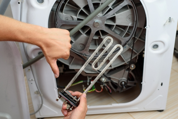 alt="Service technician repairing dryer heating element"