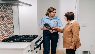 Mr. Appliance professional and woman talk about stoves.