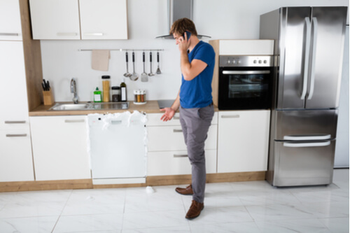 Man calling appliance repair tech to fix broken dishwasher