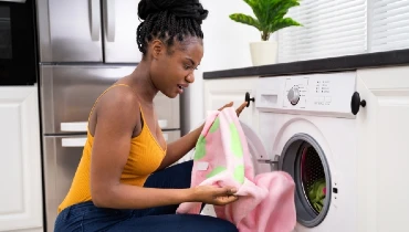 Women putting inked cloths inside dryer