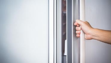 Hand on refrigerator door