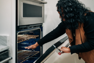 Homeowner checking the internal temperature of her broken oven appliance.