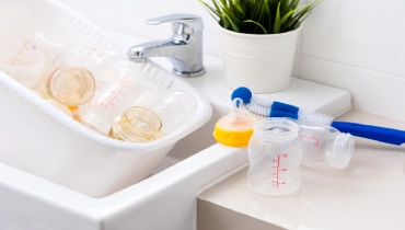 Baby bottles being washed in a kitchen sink