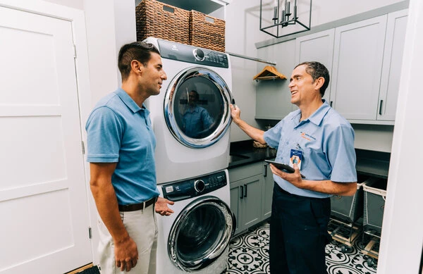 Mr. Appliance service professional helping Aurora homeowner with stackable washer and dryer repairs