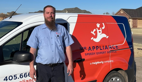 Mr. Appliance service professional in front of branded truck