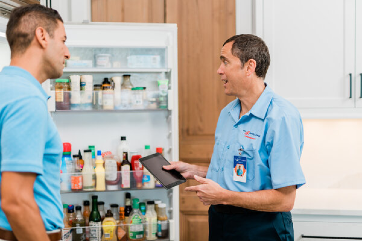 Mr. Appliance service professional helping Douglasville homeowner with refrigerator repairs