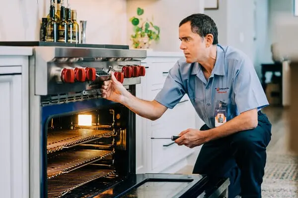 Mr. Appliance tech repairing a high-end range