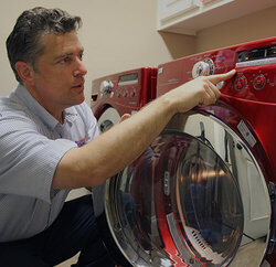 Mr. Appliance tech assessing washing machine