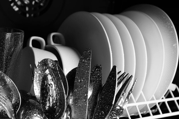 Closeup of clean wet dishes in the dishwasher.