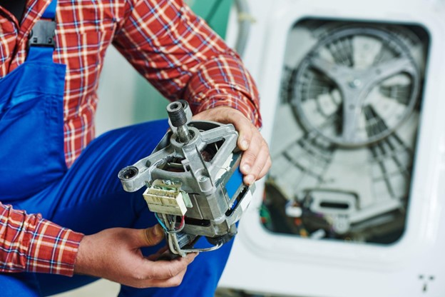 Man holding washing machine motor.