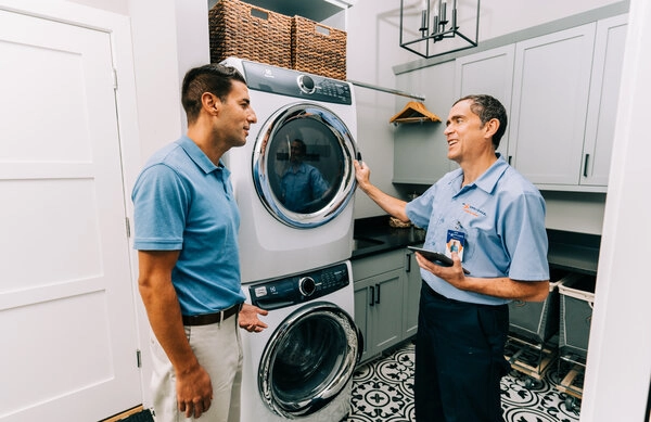 Mr. Appliance service professional helping guy with stackable washer and dryer repair