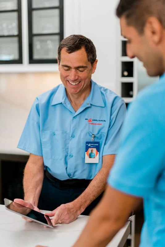 Mr. Appliance repair man showing customer his tablet