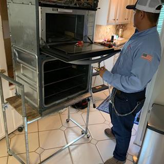 Mr. Appliance technician repairing a residential oven.