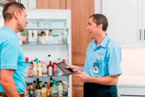 Guy looking at Mr. Appliance repair man as he helps with refrigerator repair in Fort Myers.