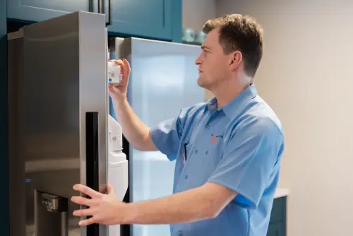 A Mr. Appliance service professional repairing an ice maker