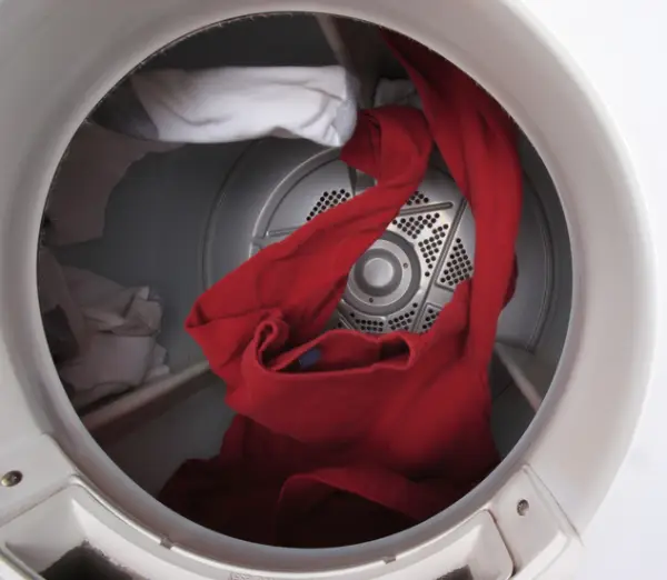 Laundry tumbling inside a properly spinning dryer.