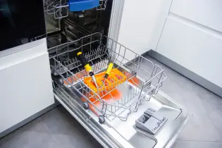 Screwdrivers inside the open dishwasher for appliance repair.