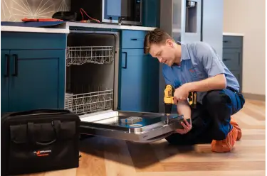 Mr. Appliance technician opening toolbox in kitchen.